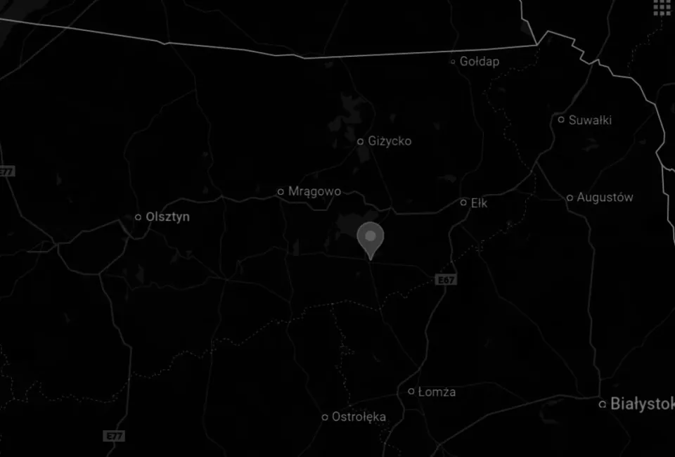 Widok z lotu ptaka na marinę z kilkoma łodziami zacumowanymi w Haven Kakumäe, na spokojnej, lustrzanej powierzchni wody, otoczoną kamiennym falochronem.