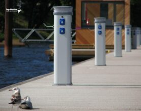 Betonowy pomost cumowniczy z postumentem zasilającym przy kei — gotowy do podłączenia zasilania.