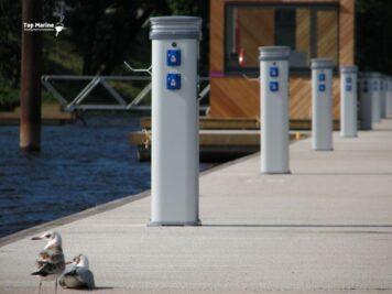 Betonowy pomost cumowniczy z postumentem zasilającym przy kei — gotowy do podłączenia zasilania.