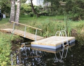 Pomost pływający z drabinką pomostową przy brzegu wody