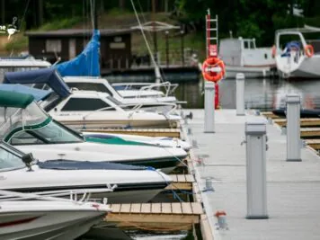 Ciężki pomost cumowniczy przy kei z postumentem zasilającym — solidna konstrukcja.